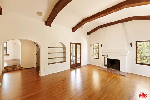 a view of a livingroom with wooden floor and a fireplace