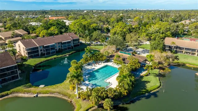 an aerial view of residential houses with outdoor space and lake view