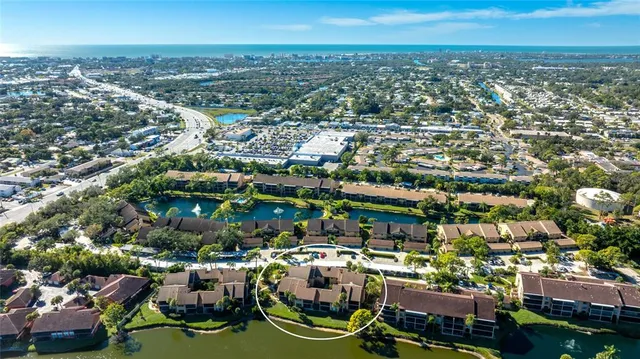 an aerial view of residential houses with outdoor space and trees