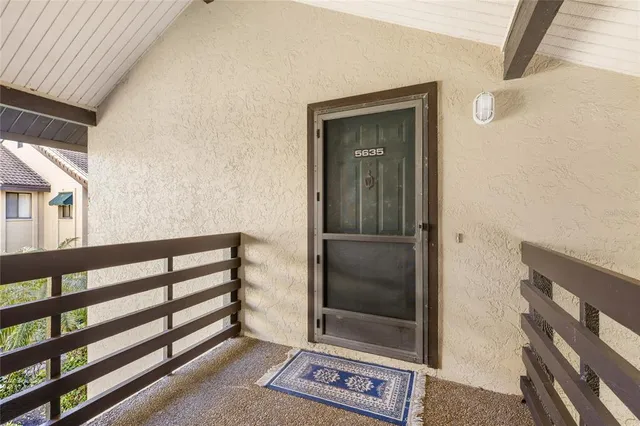 a view of a hallway with wooden floor and windows