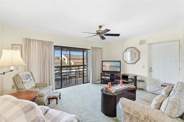 a living room with furniture kitchen view and a large window