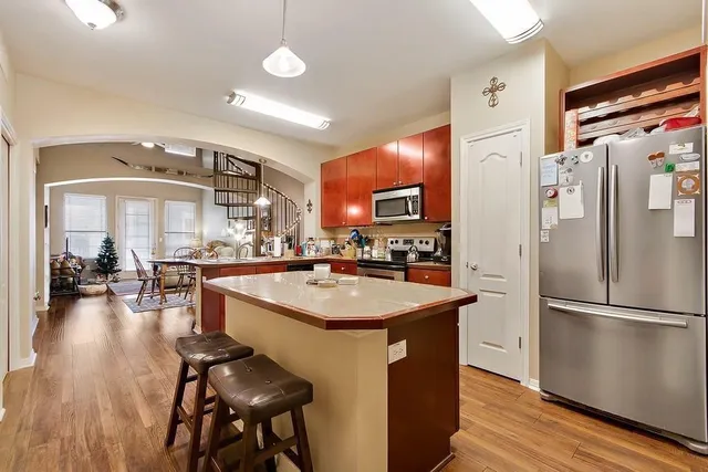 a kitchen with stainless steel appliances granite countertop a sink a stove and a refrigerator