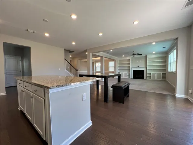 an empty room with windows and ceiling fan