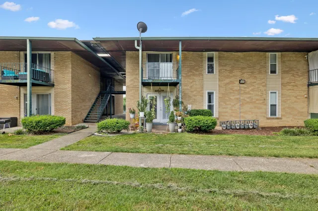 a front view of a house with a yard and potted plants