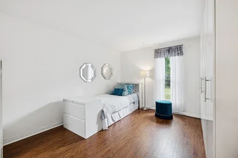 a bedroom with bed and wooden floor