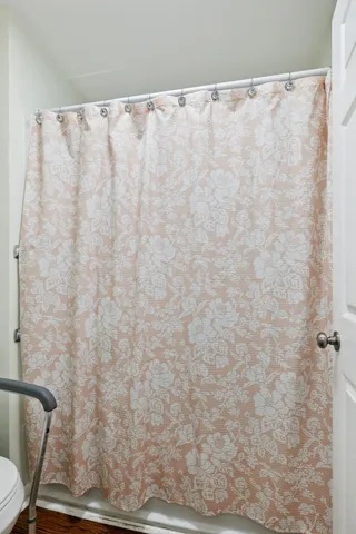 a bathroom with a white shower curtain and a toilet