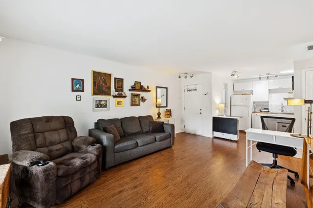 a view of living room kitchen with furniture and wooden floor