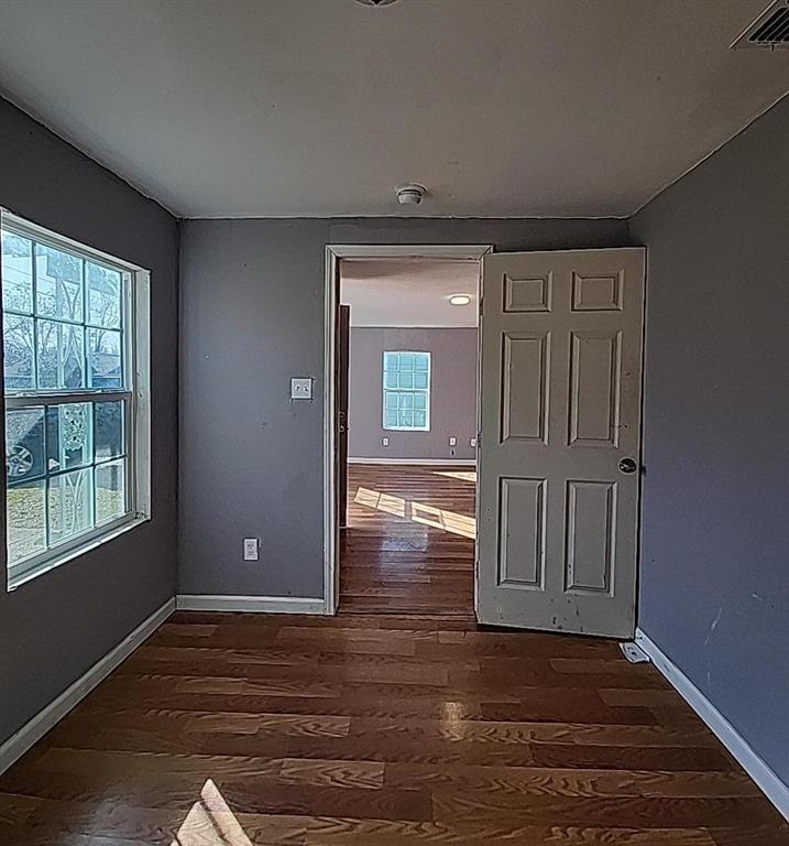 108 Monroe Street Cleburne, TX 76033 - Photo 12 of 14 an empty room with wooden floor cabinet and windows