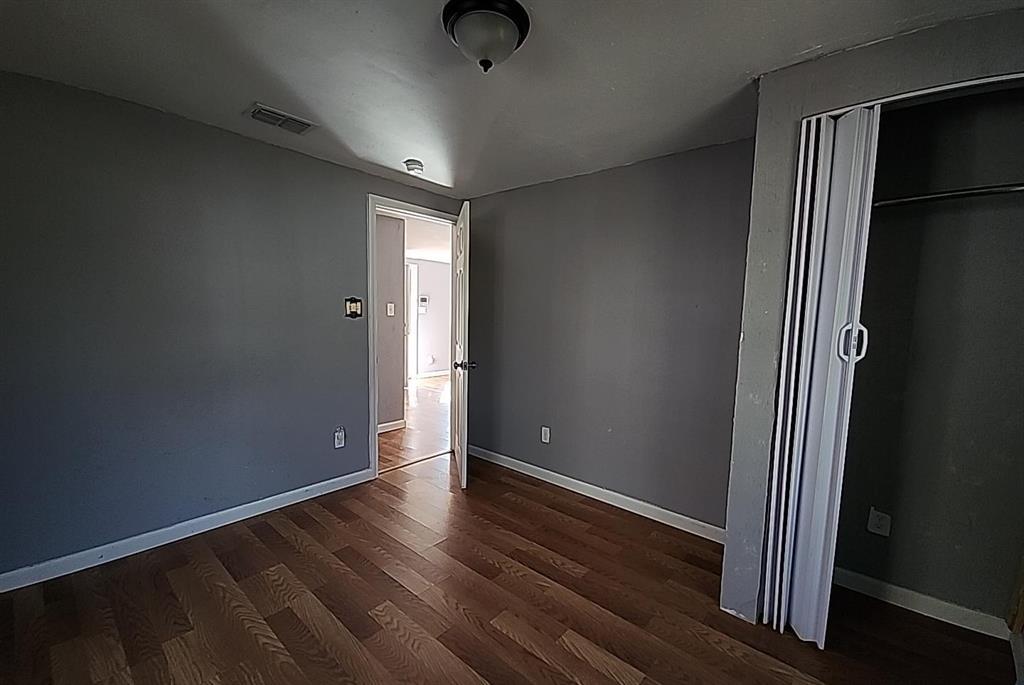 108 Monroe Street Cleburne, TX 76033 - Photo 14 of 14 an empty room with wooden floor and windows