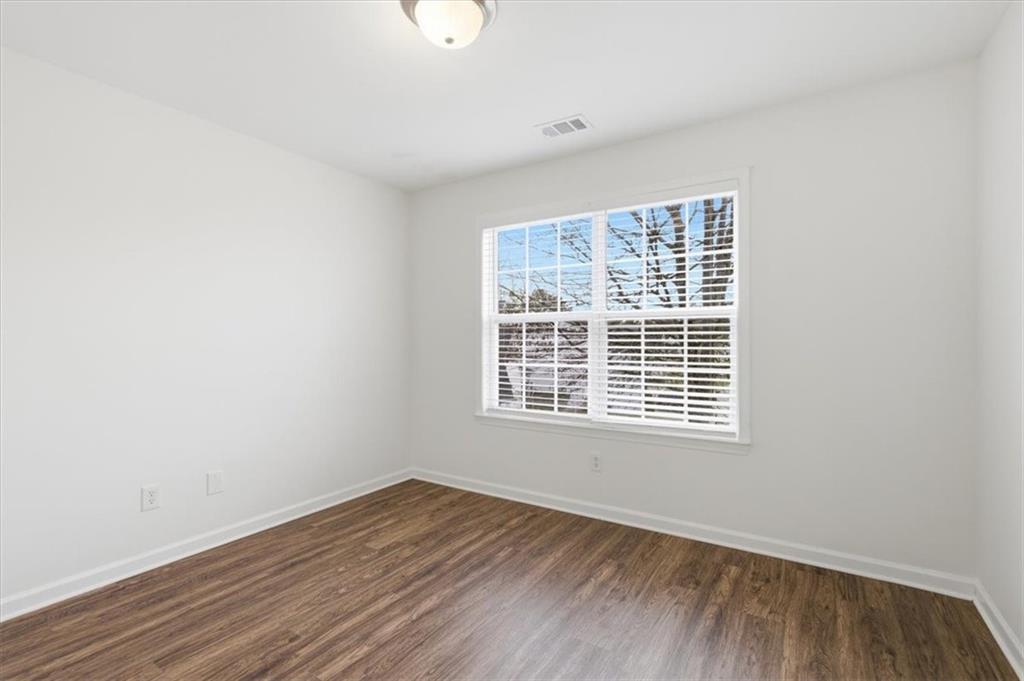 836 Topaz Valley Canton, GA 30114 - Photo 26 of 33 a view of an empty room with wooden floor and a window
