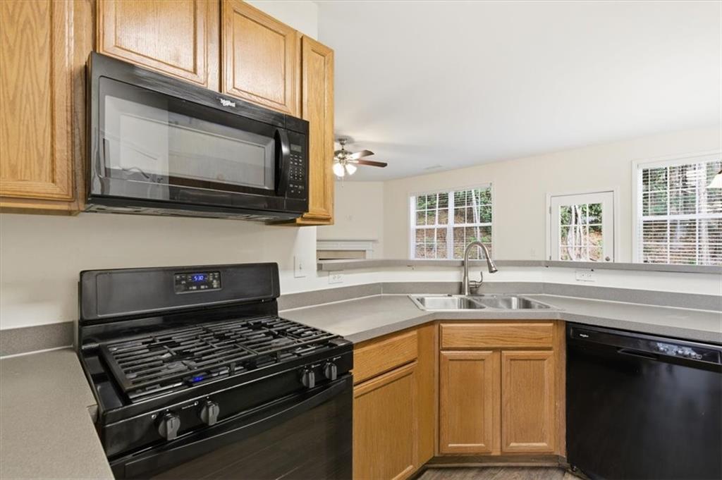 836 Topaz Valley Canton, GA 30114 - Photo 8 of 33 a kitchen with granite countertop a stove sink and microwave