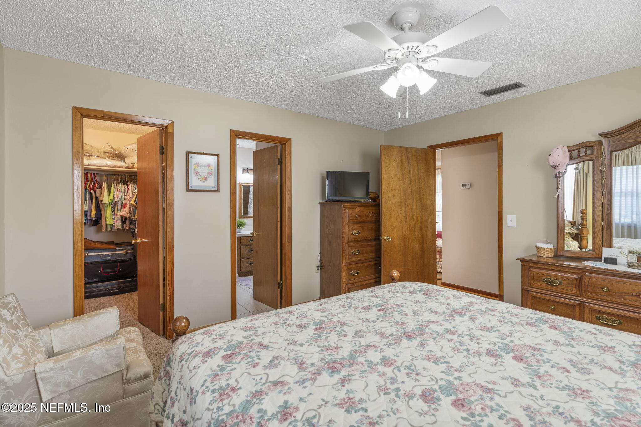 5893 George Hodges Road Macclenny, FL 32063 - Photo 26 of 56 a bedroom with a large bed a chandelier and closet