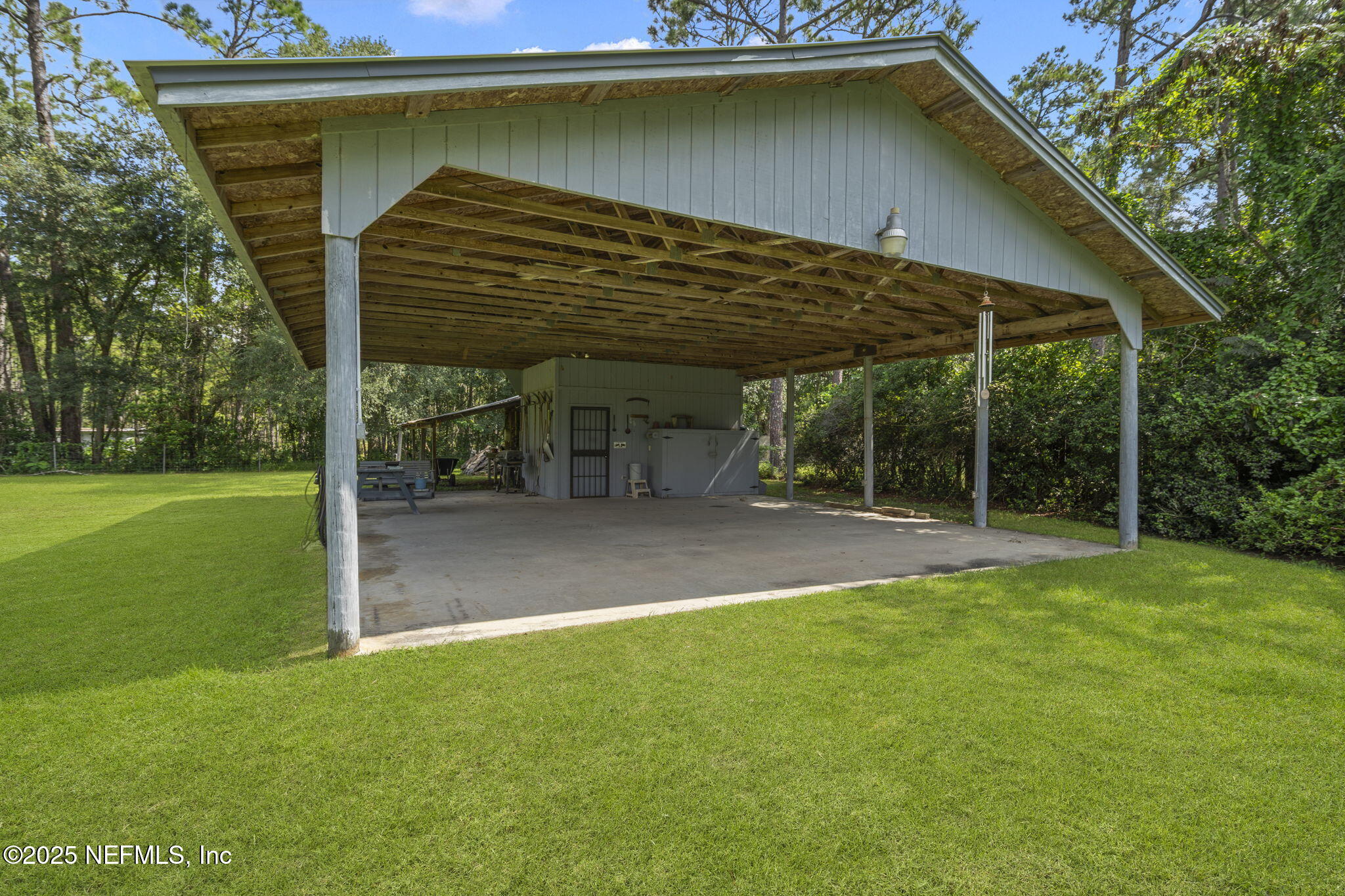 5893 George Hodges Road Macclenny, FL 32063 - Photo 50 of 56 a view of a backyard with table and chairs under an umbrella