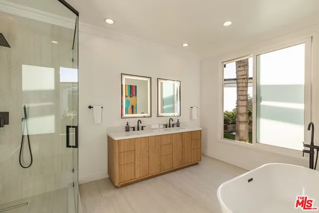 a bathroom with a tub sink shower and mirror