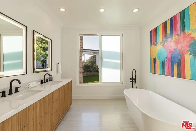 a bathroom with a tub a sink and a large window