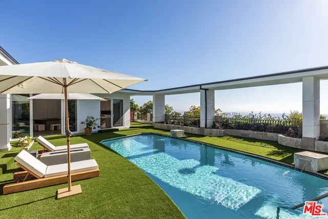 a view of a house with swimming pool and sitting area