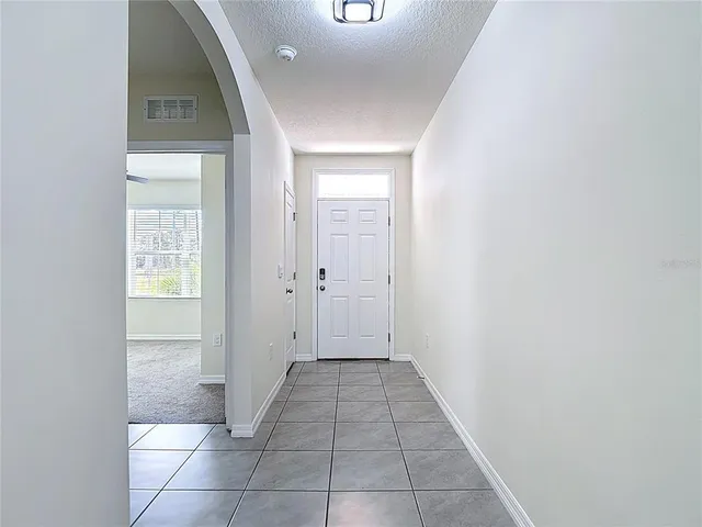 a view of a hallway with wooden floor and a bathroom