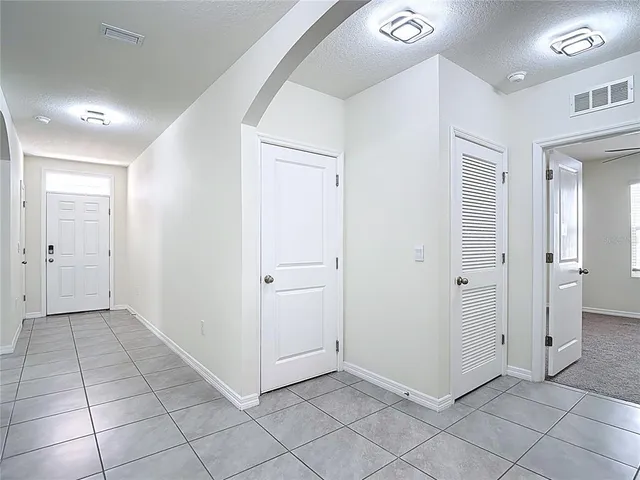 a view of a livingroom with a ceiling fan & entryway