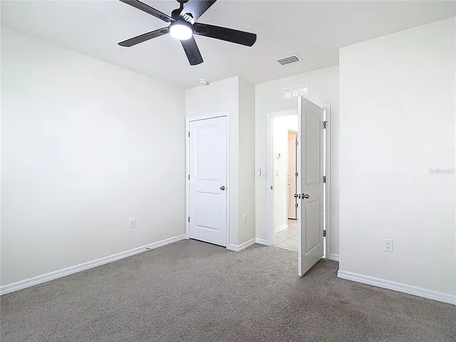 an empty room with a window and a fan