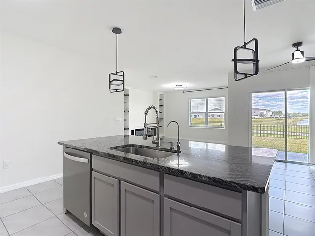 a kitchen with stainless steel appliances granite countertop a sink a stove a refrigerator and cabinets