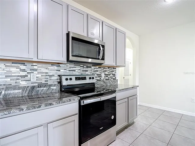 a kitchen with stainless steel appliances granite countertop a refrigerator and a stove