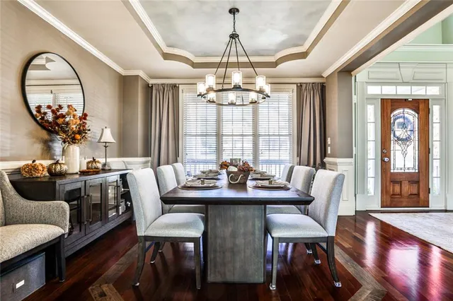 a view of a dining room with furniture a chandelier and wooden floor