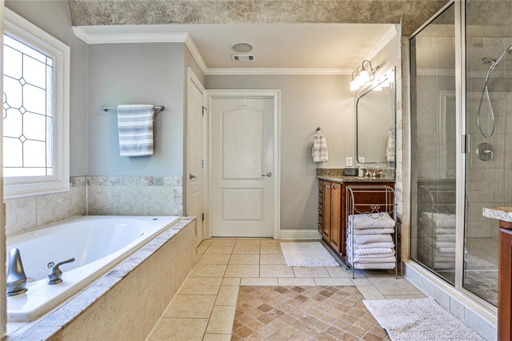 872 Pathview Court Dacula, GA 30019 - Photo 37 of 62 a bathroom with a tub a mirror and a shower