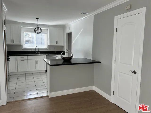 a kitchen with granite countertop a sink and cabinets