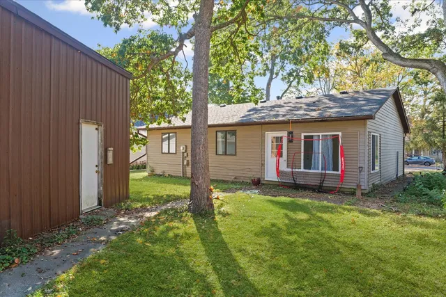 a view of a house with a yard tree and a fence
