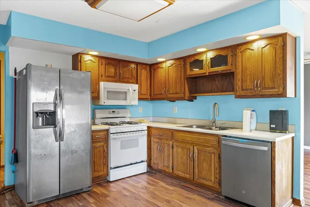 a kitchen with a sink cabinets stainless steel appliances and a window