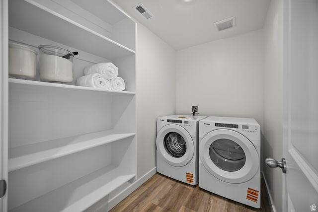 2202 Wolverine Way, Unit 2529 Washington, UT 84780 - Photo 19 of 27 Dedicated laundry room featuring wood-finish flooring, a washer and dryer, recessed lighting, and extensive built-in shelving