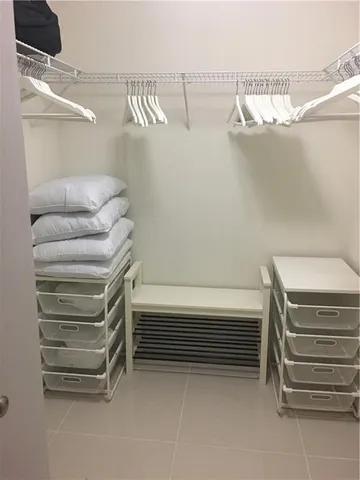 a view of walk in closet with empty racks