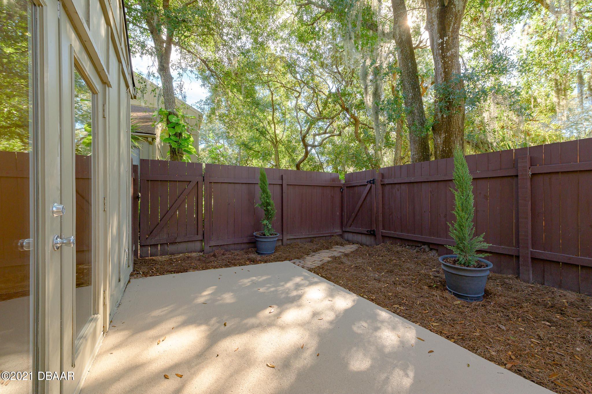 11 Birchwood Trail Ormond Beach, FL 32174 - Photo 23 of 24 a view of backyard with potted plants and wooden fence