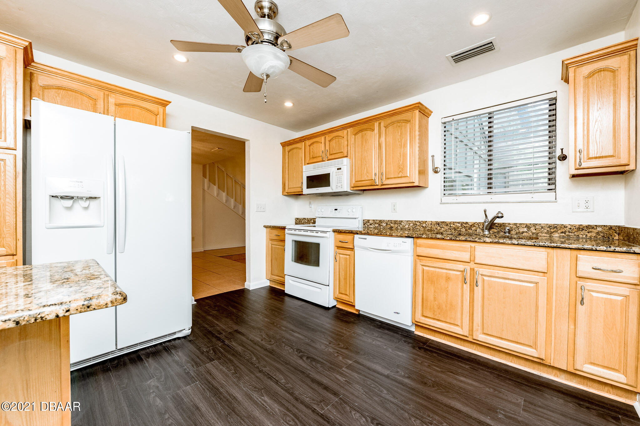 11 Birchwood Trail Ormond Beach, FL 32174 - Photo 6 of 24 a kitchen with stainless steel appliances granite countertop a stove a sink and white cabinets with wooden floors