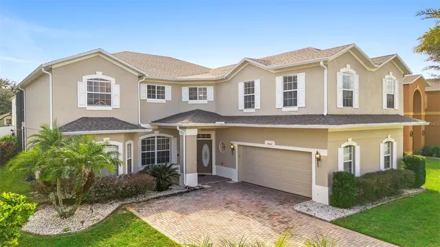 a view of a white house with a yard and plants