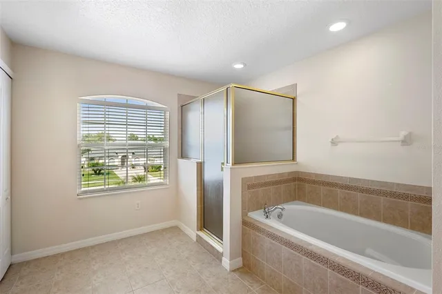 a bathroom with a tub a sink and a window