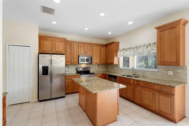 a kitchen with stainless steel appliances granite countertop a refrigerator and a sink