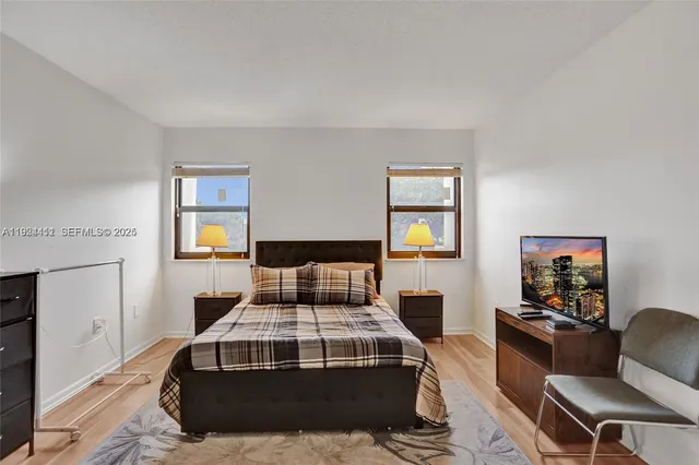a bedroom with a bed and wooden floor