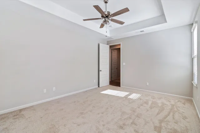 an empty room with a ceiling fan and a window