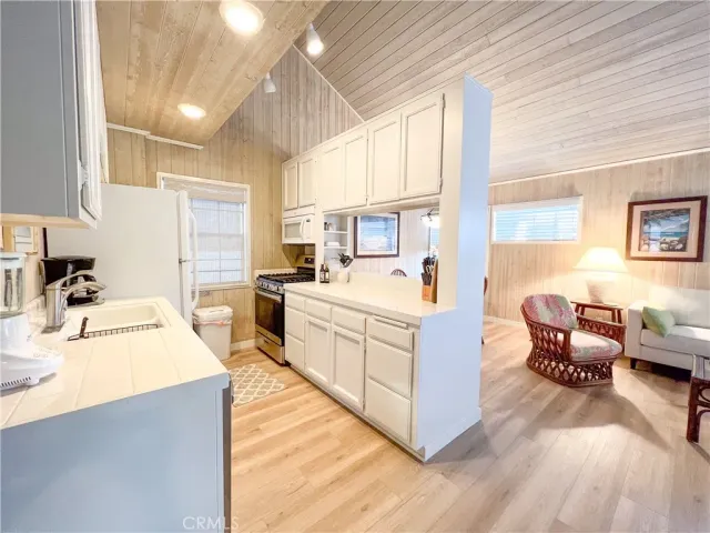a large white kitchen with cabinets a sink and a stove