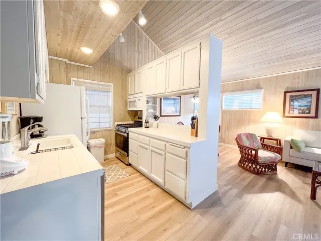a large white kitchen with cabinets a sink and a stove