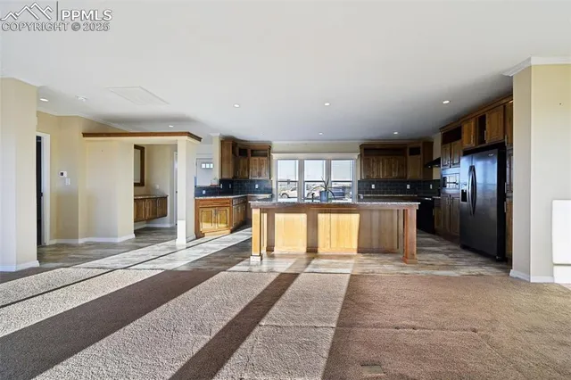 a kitchen with stainless steel appliances granite countertop a sink and a refrigerator