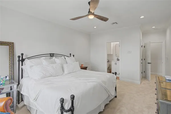 a bedroom with a bed and a flat tv screen on dresser