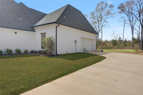 a view of a house with backyard and trees