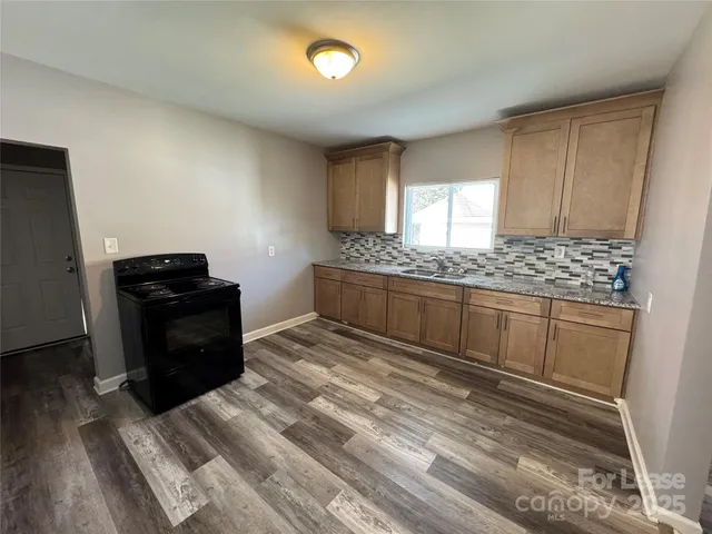 a kitchen with granite countertop wooden cabinets and black appliances