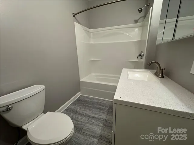 a white toilet sitting next to a bath tub