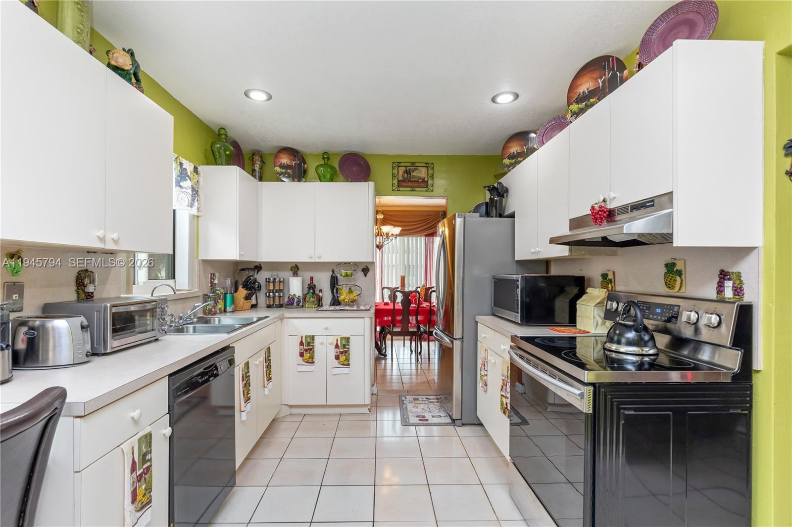 15244 Southwest 108th Court Miami, FL 33157 - Photo 14 of 47 a kitchen with a sink stove top oven and cabinets