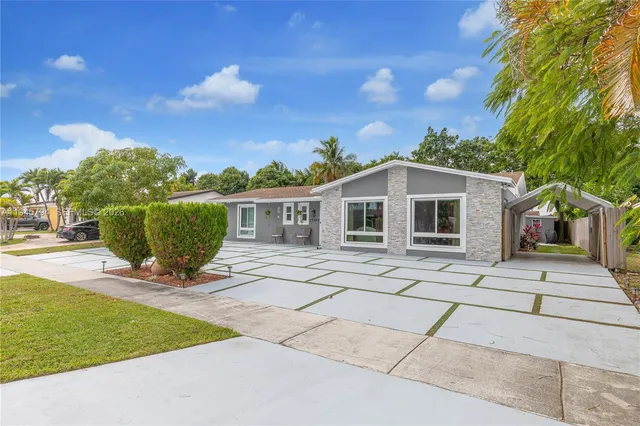 a view of a house with backyard and a garden