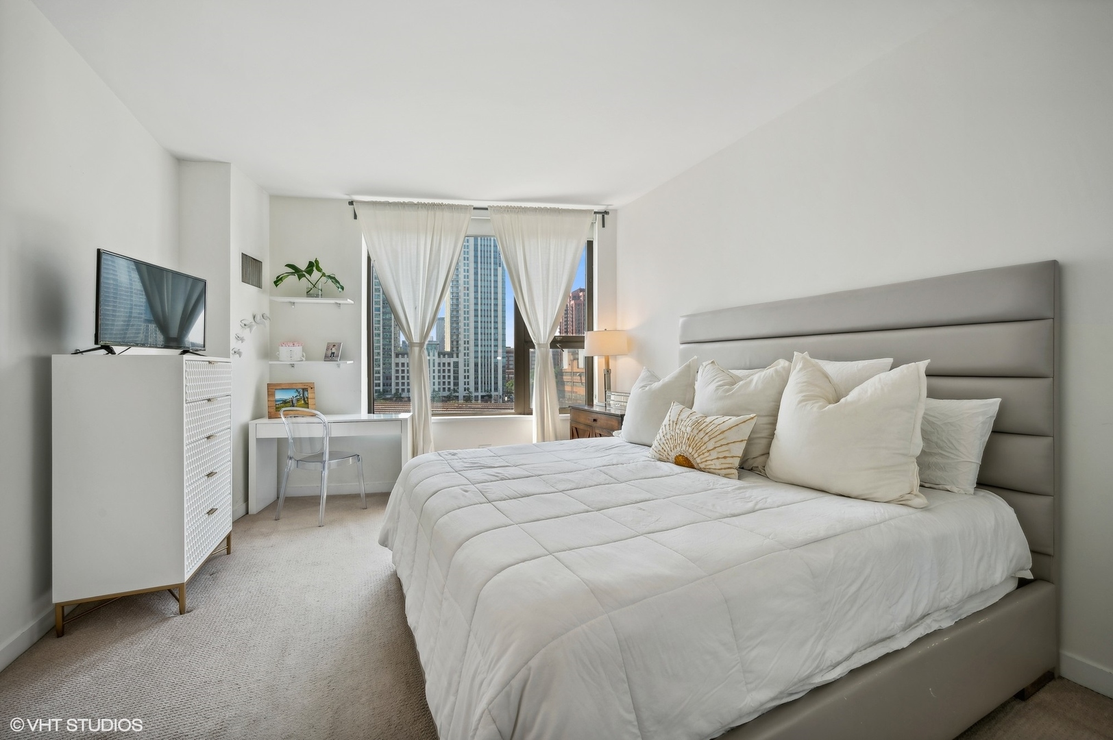 501 North Clinton Street, Unit 604 Chicago, IL 60654 - Photo 12 of 25 a bedroom with a bed flat screen tv and a large window