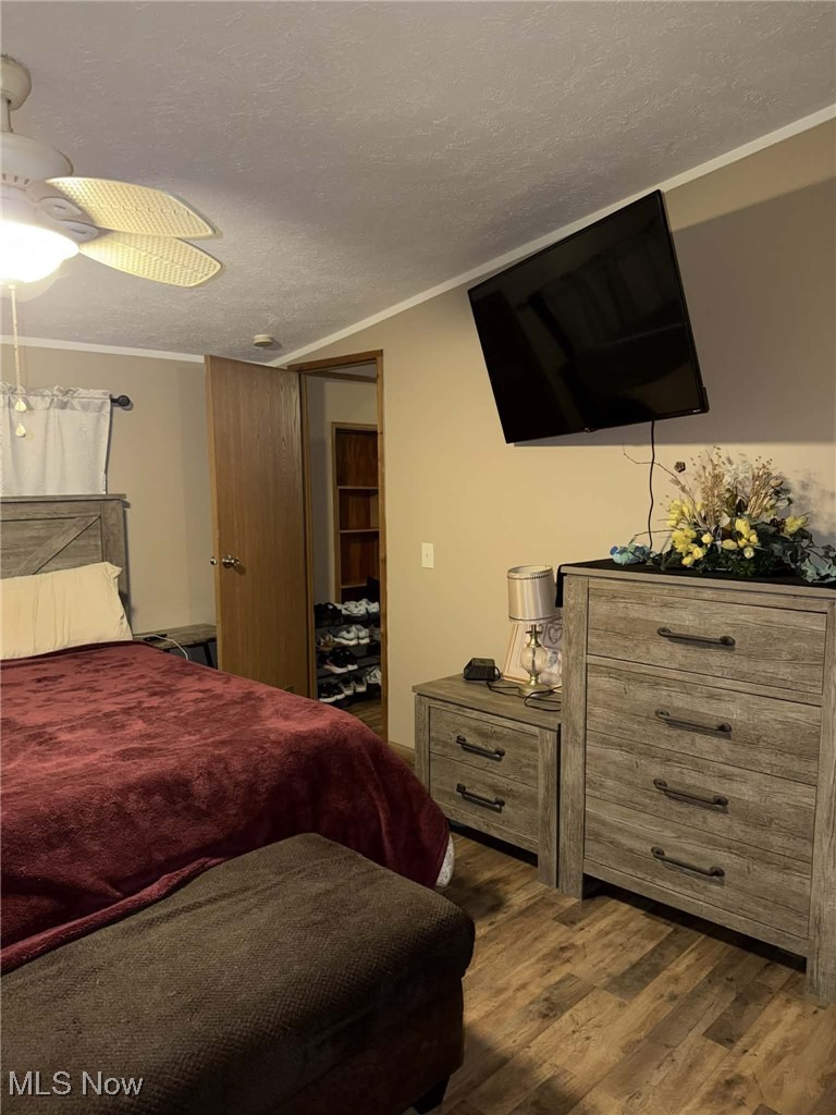56 3rd Street Rayland, OH 43943 - Photo 28 of 46 Bedroom featuring a textured ceiling, ceiling fan, ornamental molding, and dark wood-style flooring